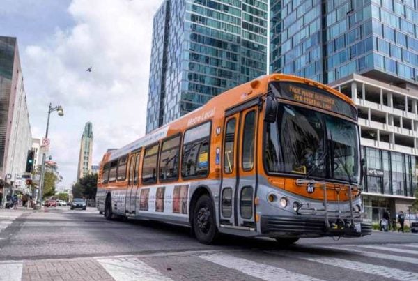 Orange metro bus driving on busy street